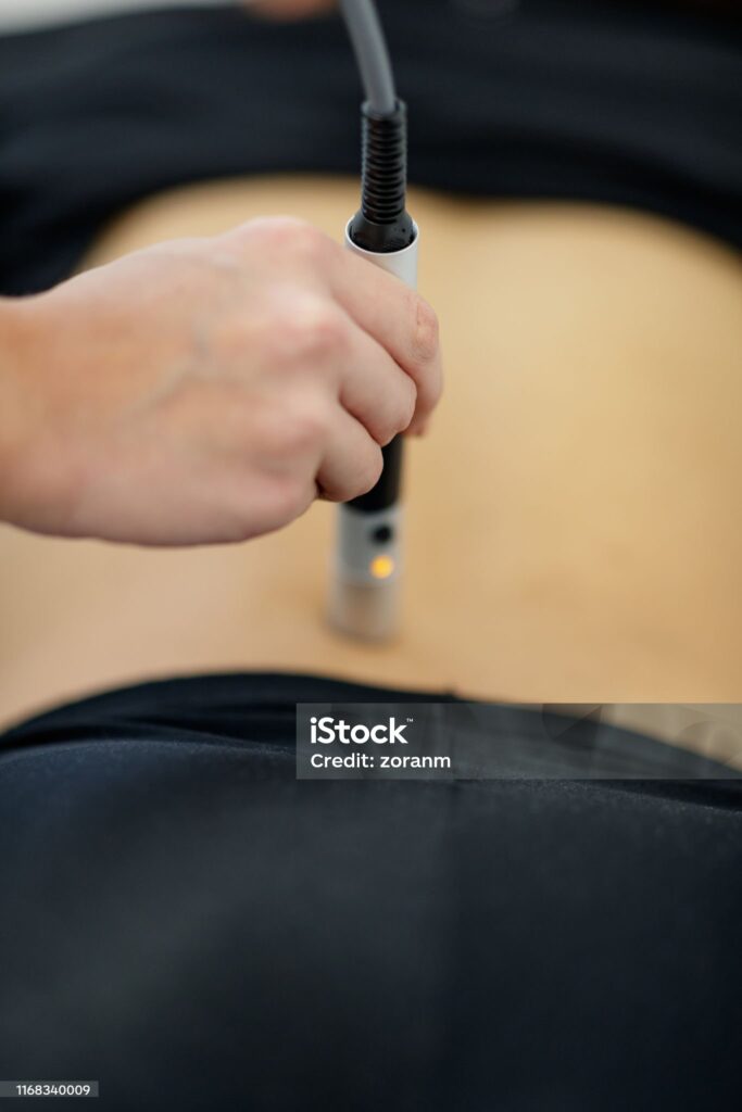 A person receiving laser therapy on their back