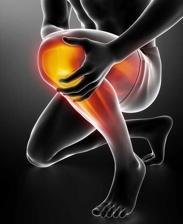 person kneeling and holding their knee